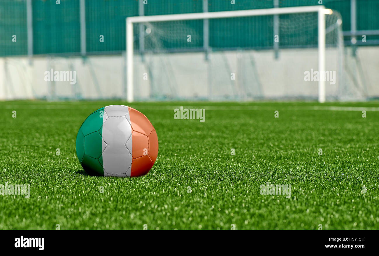 Soccer ball with the flag from Ireland on the green field Stock Photo