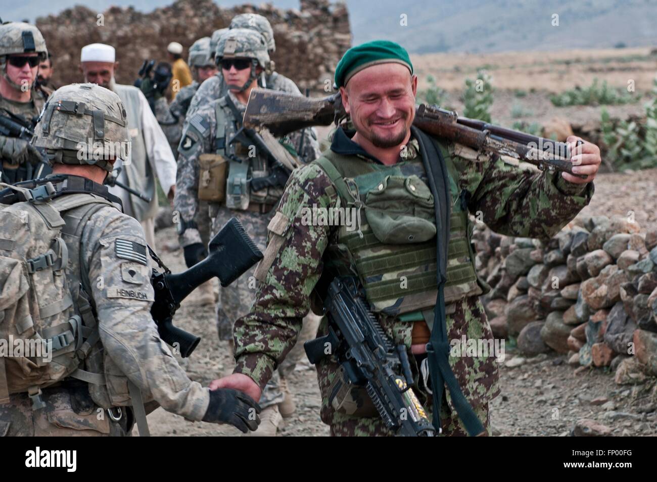 An Afghan soldier smiles after discovering a cache of weapons during a joint operation with U.S. Army soldiers November 4, 2010 in the Dag Mene, Kunar Province, Afghanistan. Stock Photo