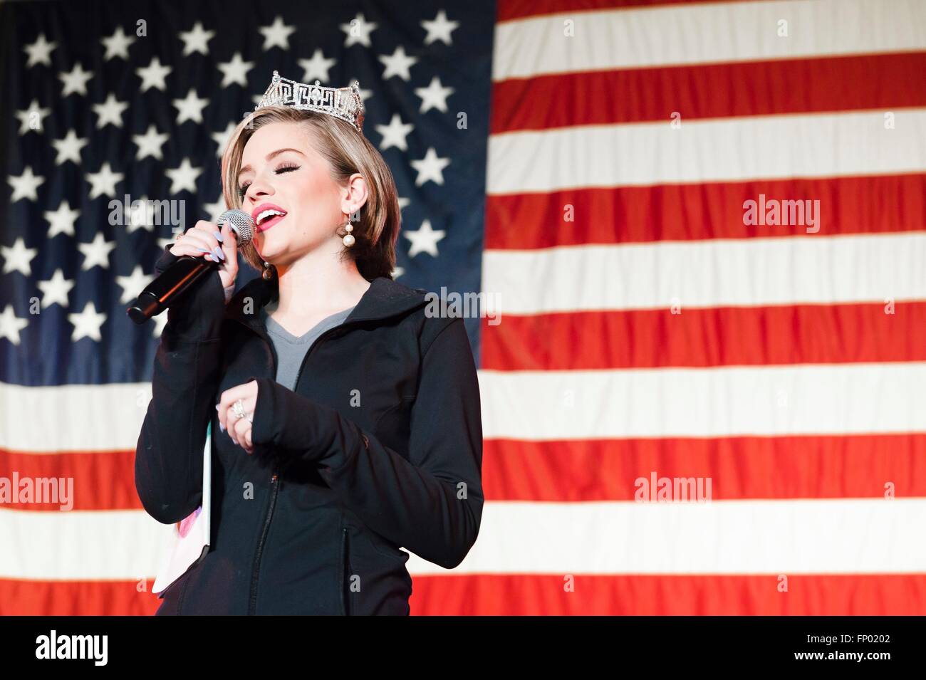 Betty Cantrell, Miss America 2016, sings for the troops in front of a giant American flag during a visit to service members as part of the USO Spring Tour at Joint Base Elmendorf-Richardson March 12, 2016 in Alaska. Stock Photo