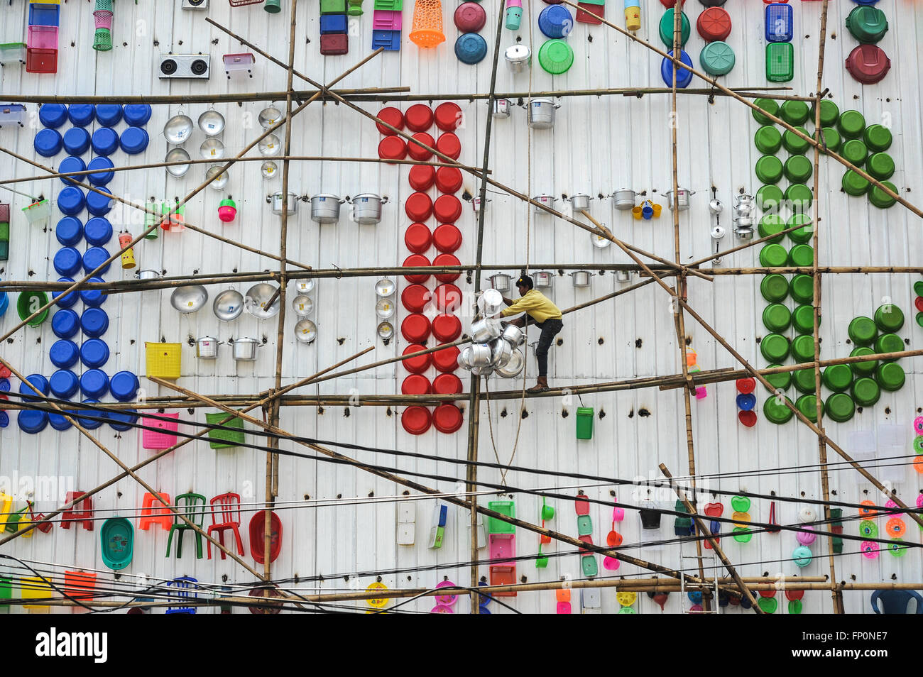 Jakarta, Indonesia. 17th Mar, 2016. A worker arranges assorted commodities on the wall outside a store in West Jakarta, Indonesia, March 17, 2016. The exterior of the store was decorated with various of commodities that laid out nicely to attract consumers' attention. Credit:  Veri Sanovri/Xinhua/Alamy Live News Stock Photo