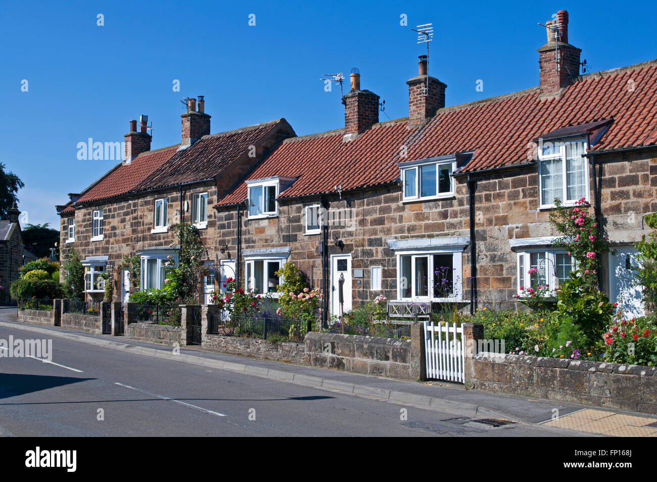 Row of attractive old terraced stone-built cottages with red pantiled roofs in Great Ayton village, North Yorkshire, England UK Stock Photo