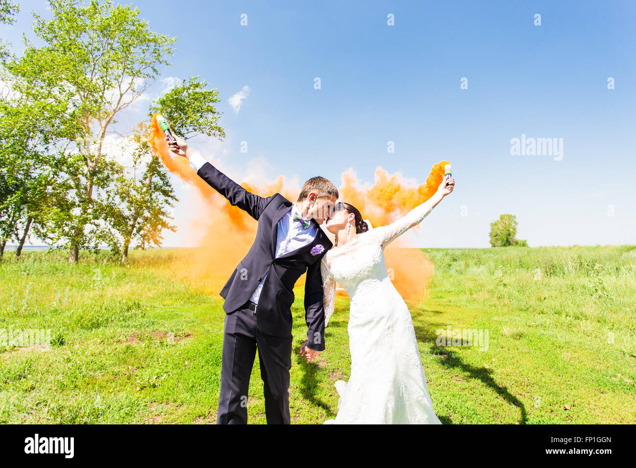 Wedding couple kissing with color smoke in the summer park Stock Photo ...