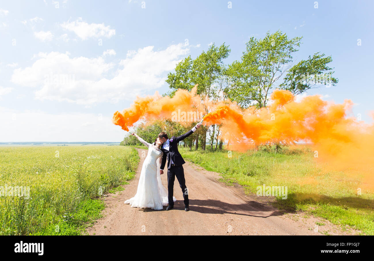Wedding couple kissing with color smoke in the summer park Stock Photo ...