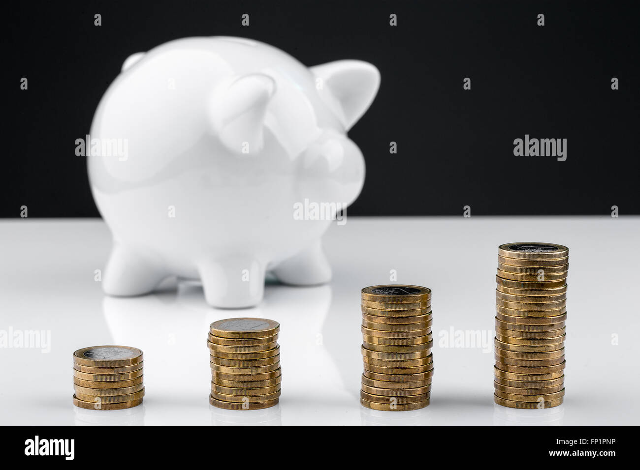 White piggy bank with stack of coins Stock Photo - Alamy