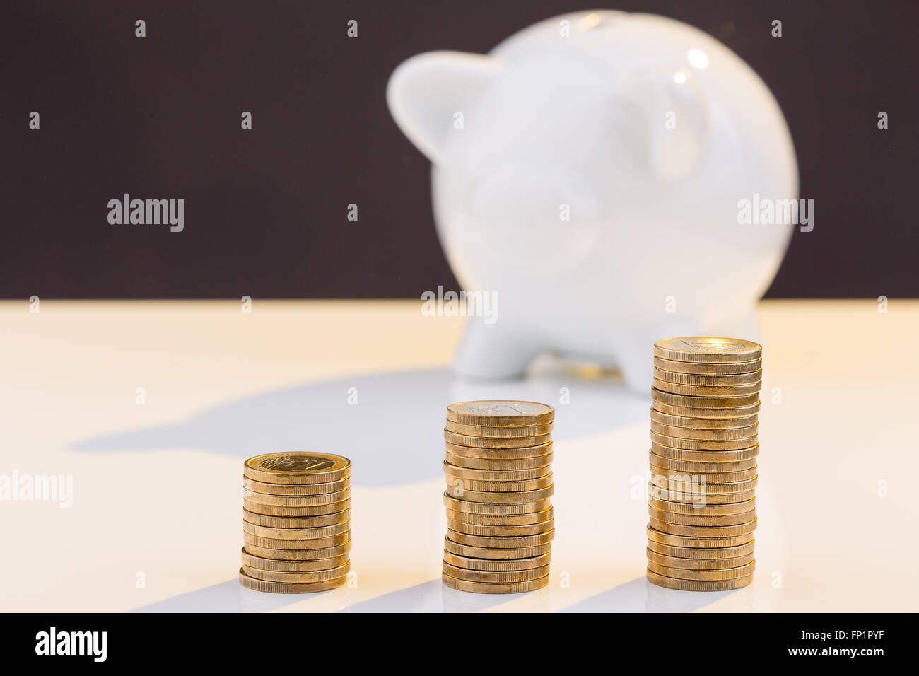 White piggy bank with stack of coins Stock Photo - Alamy
