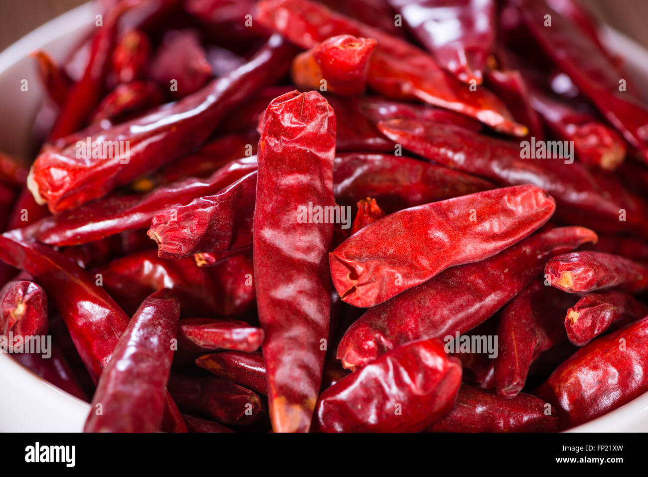 Red Chillis (close-up shot, selective focus) on wooden background Stock Photo