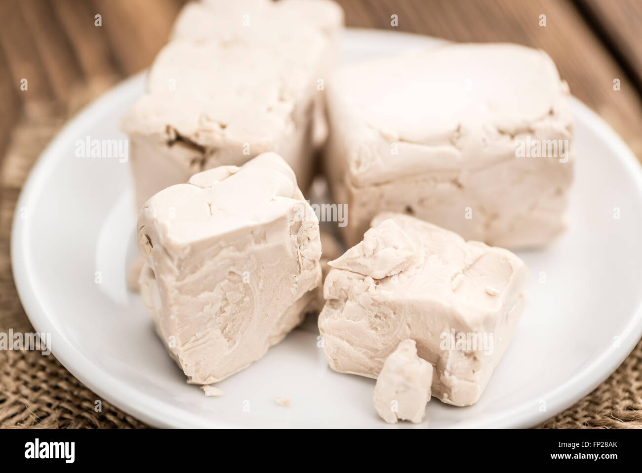Portion of fresh Yeast (selective focus) on wooden background Stock Photo