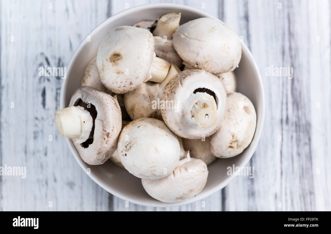 Portion of fresh white Mushrooms (selective focus) on wooden background Stock Photo
