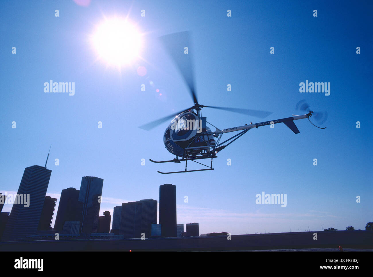 Houston Police helicopter taking off from top of tall building Stock