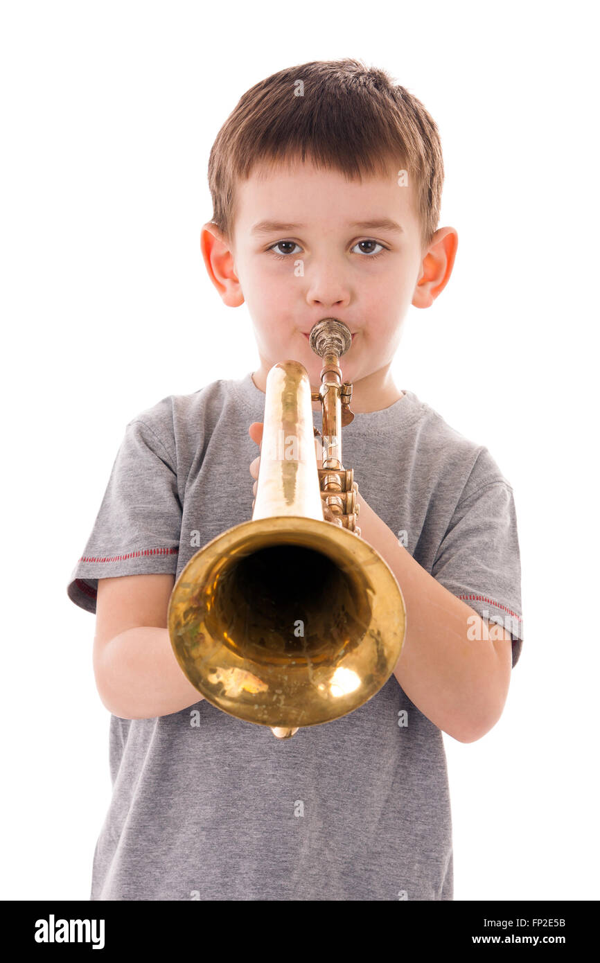 young boy blowing into a trumpet against white background Stock Photo