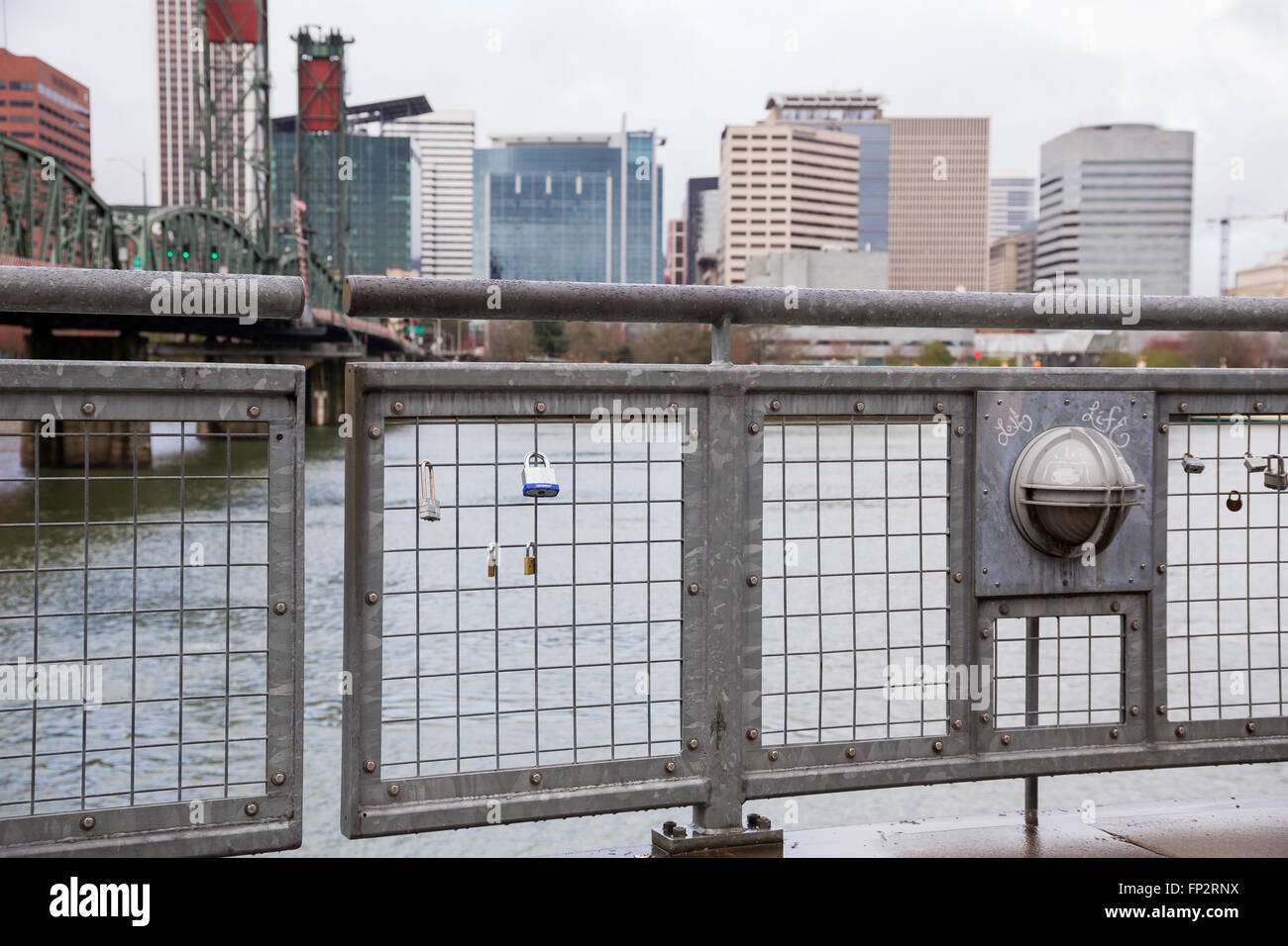 PORTLAND, OR - FEBRUARY 27, 2016: Locks are locked to a fence on a bridge across from downtown Portland Oregon in an attempt to Stock Photo