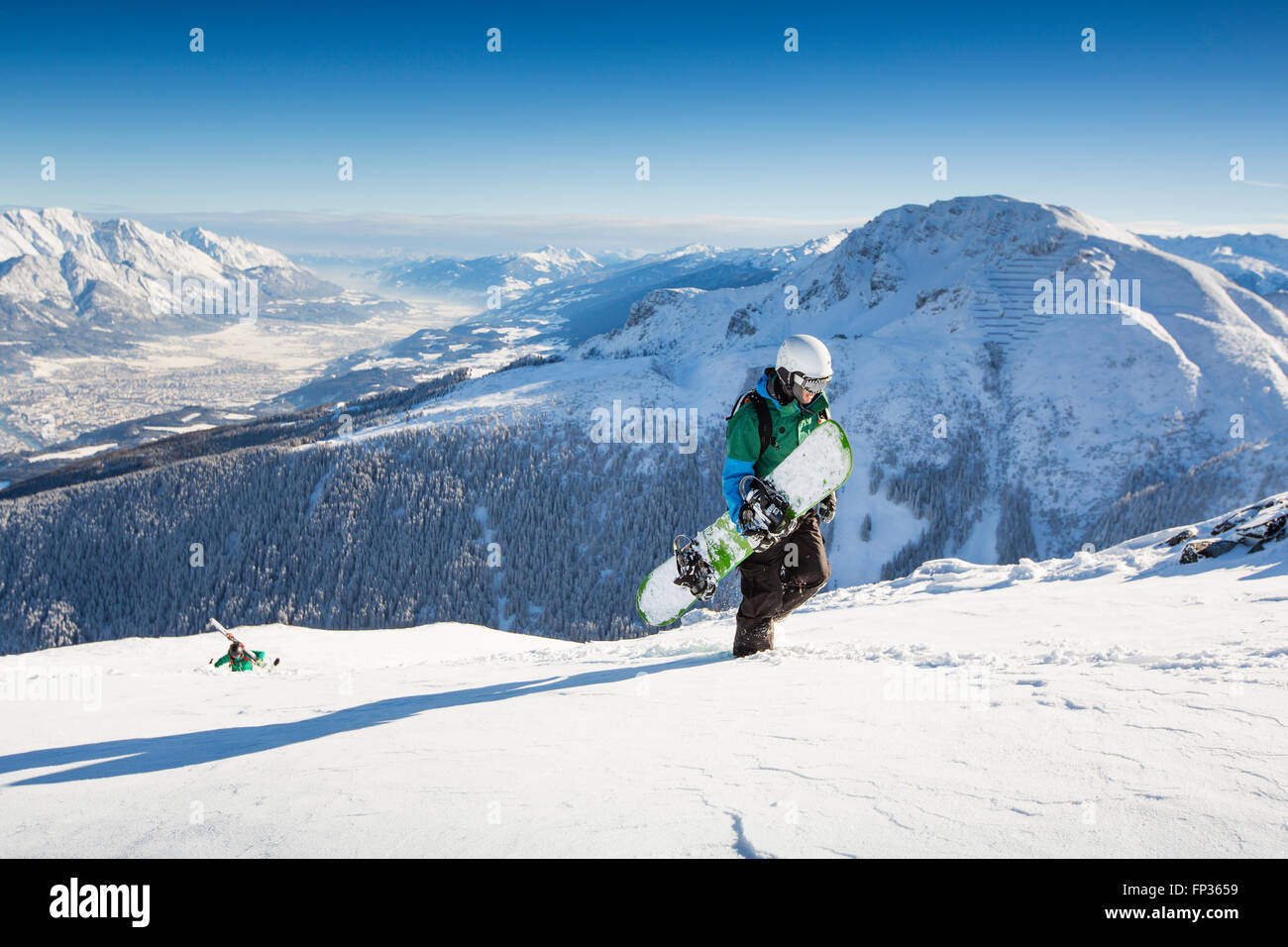 Snowboarders during the ascent overlooking Innsbruck and Inntal valley, Axamer Lizum, Tyrol, Austria Stock Photo