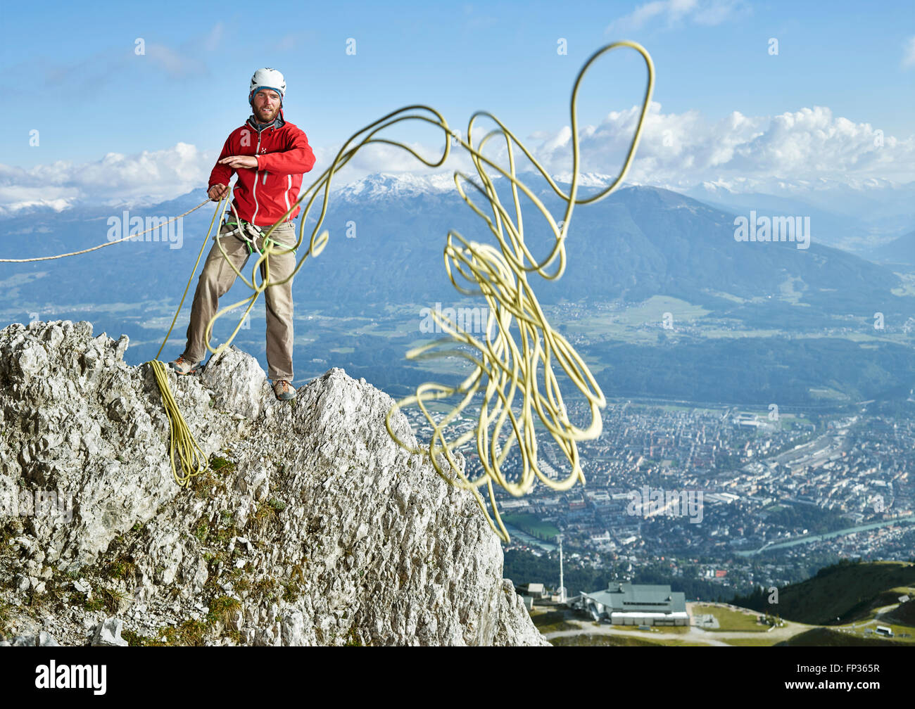 Climber on rock throwing a climbing rope, behind Innsbruck, Northern Alps, Tyrol, Austria Stock Photo