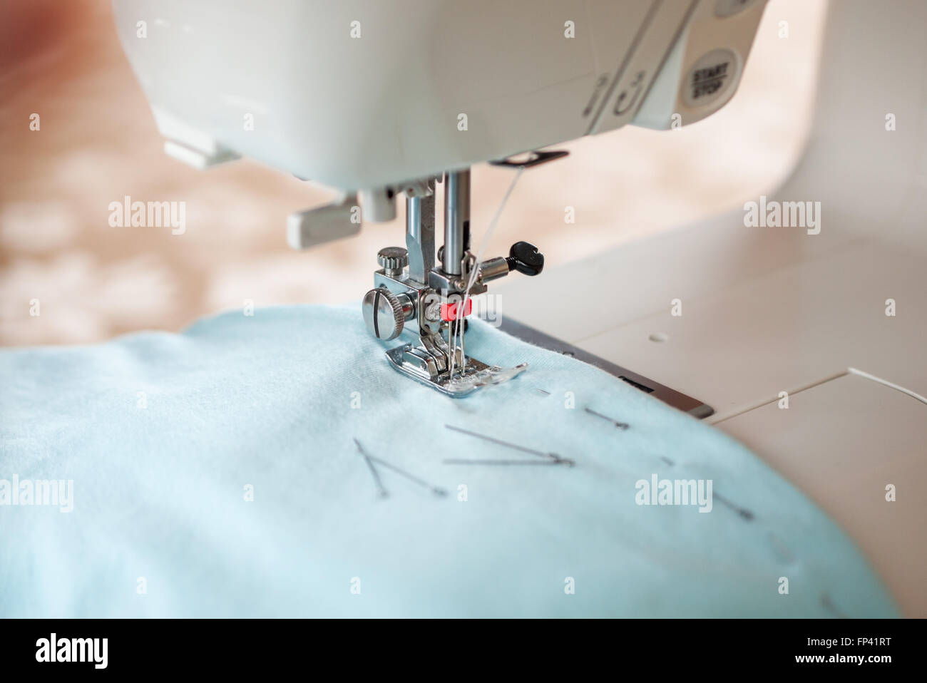 Sewing machine, blue fabric and pins Stock Photo
