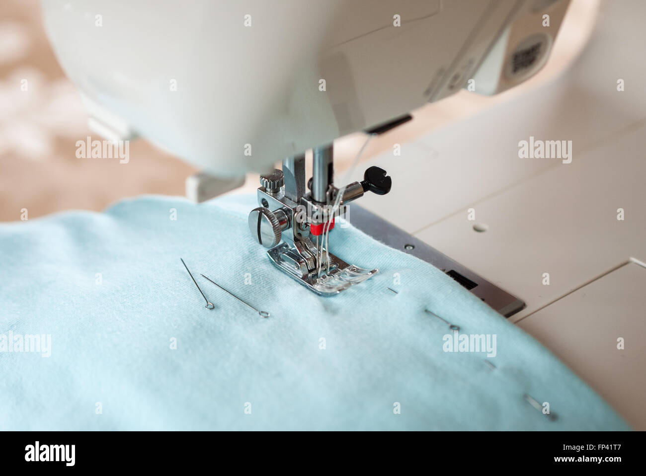 Sewing machine, blue fabric and pins Stock Photo