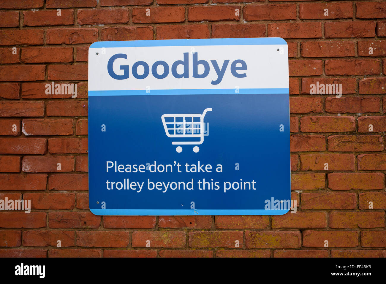 Goodbye. Please Don't take a trolley beyond this point' sign on a wall in a Tesco car park Stock Photo