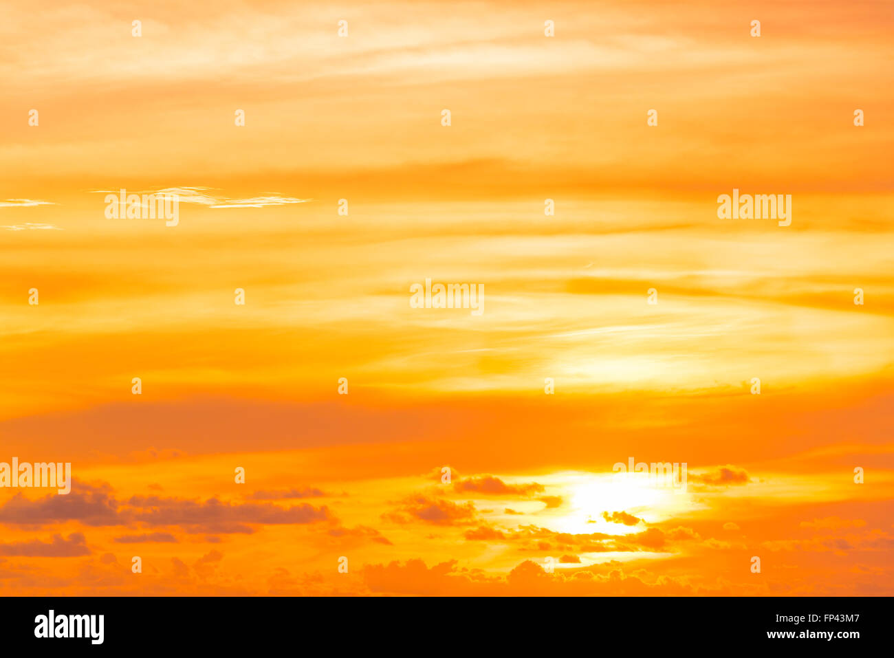 Sunset / sunrise orange sky with clouds, light rays and other atmospheric effect. Stock Photo