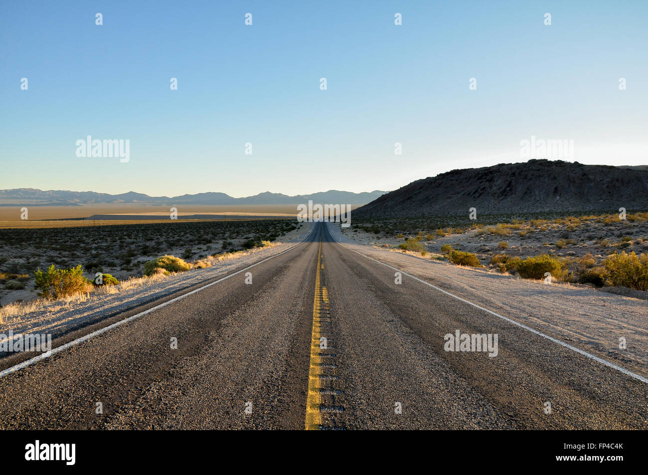 Long straight desert road at Daylight Pass in Death Valley National Park Stock Photo