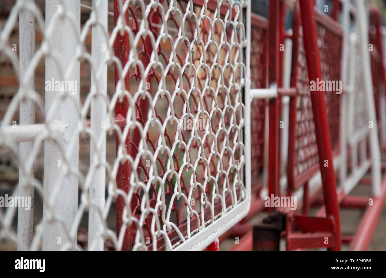 Close up of white and red metal chain fence, barrier on the side of railway path Stock Photo