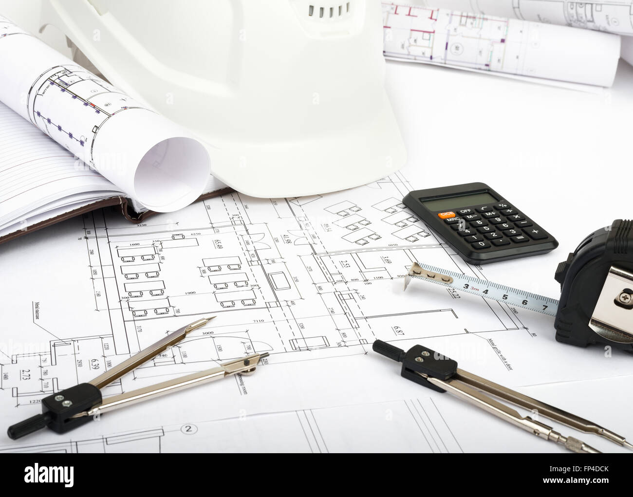 Architecture plan and rolls of blueprints with meter and helmet ...
