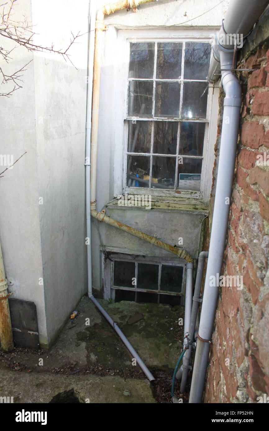 Old Victorian sash windows with ancient gutters and crumbling walls Stock Photo