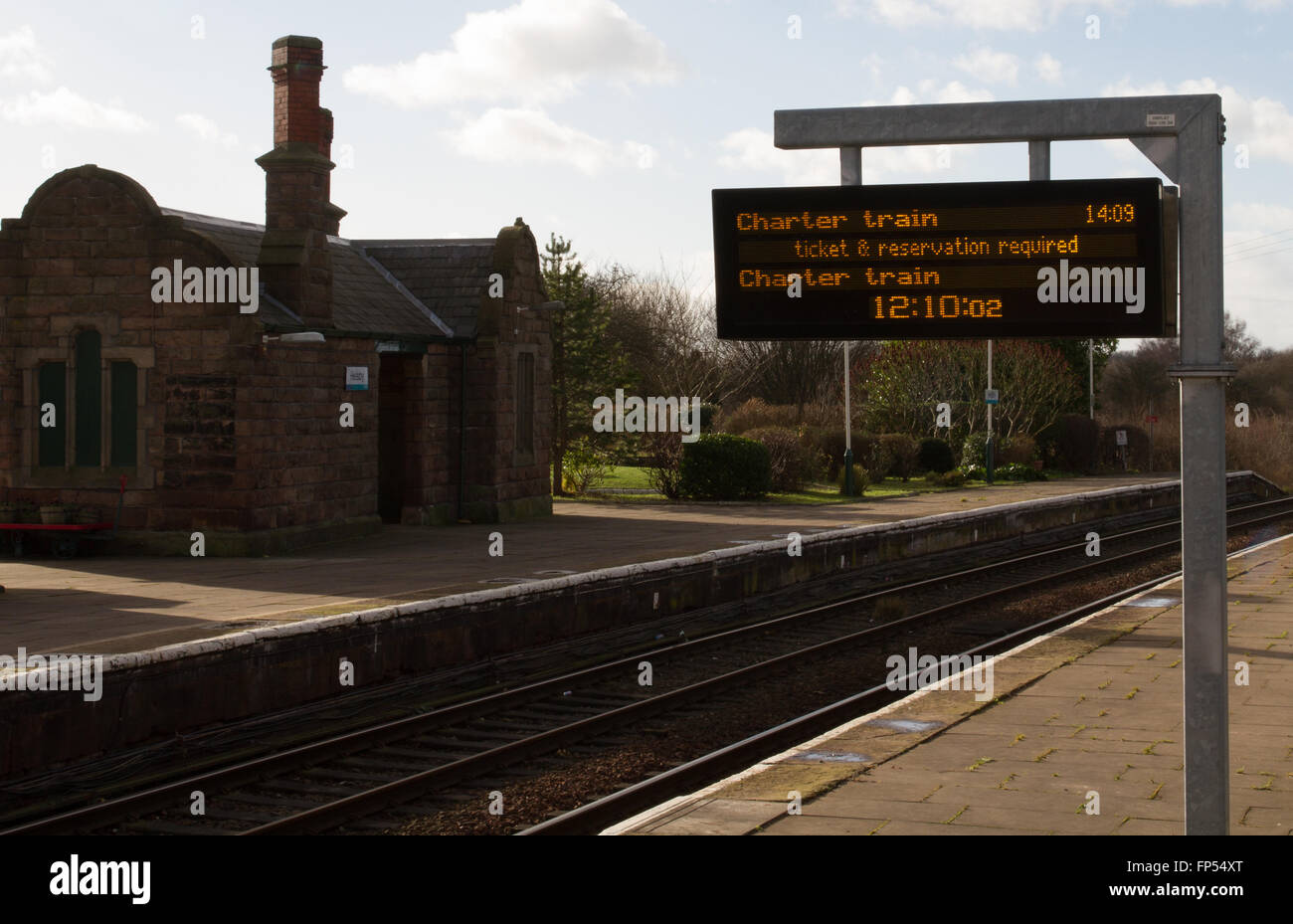 The modern customer information screen and Victorian station buildings at Helsby station in Cheshire - Now operated by Transport for Wales Keolis Amey Stock Photo