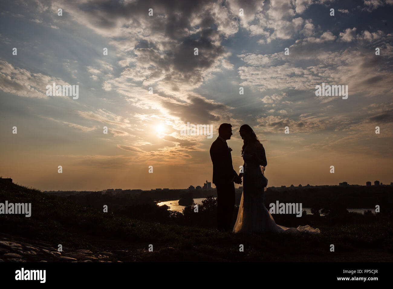 Silhouette of a young bride and groom on sunset background. Wedding ...