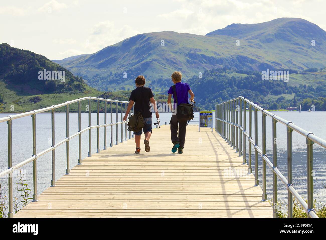 Lake District National Park. Boys going fishing. Aira Force Jetty lake Ullswater. Lake District National Park, Cumbria, England. Stock Photo