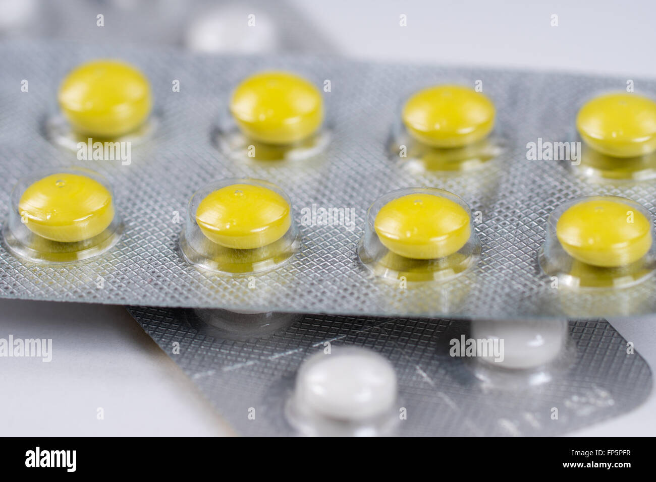 close up of yellow and white pills in blisters Stock Photo