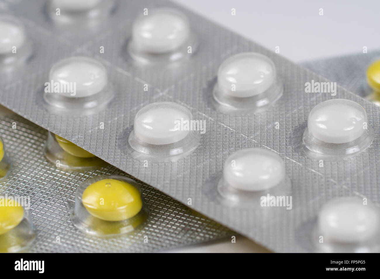 close up of white and yellow pills in blisters Stock Photo