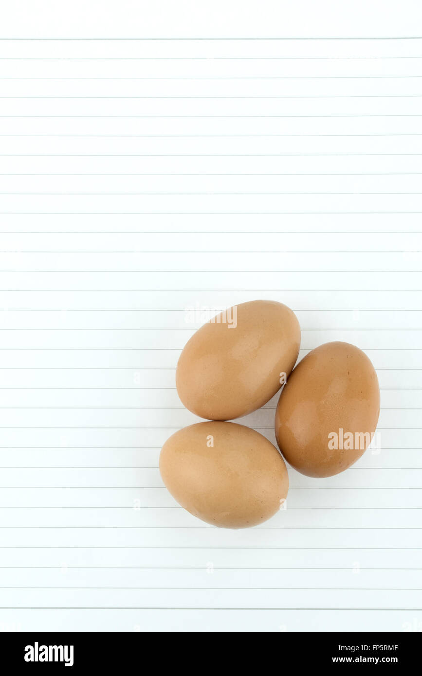 Three wet eggs with copy space on blank note paper Stock Photo