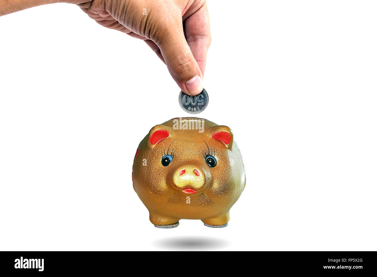 Woman's hand inserting coins into a piggy bank,concept for business finance background. Stock Photo