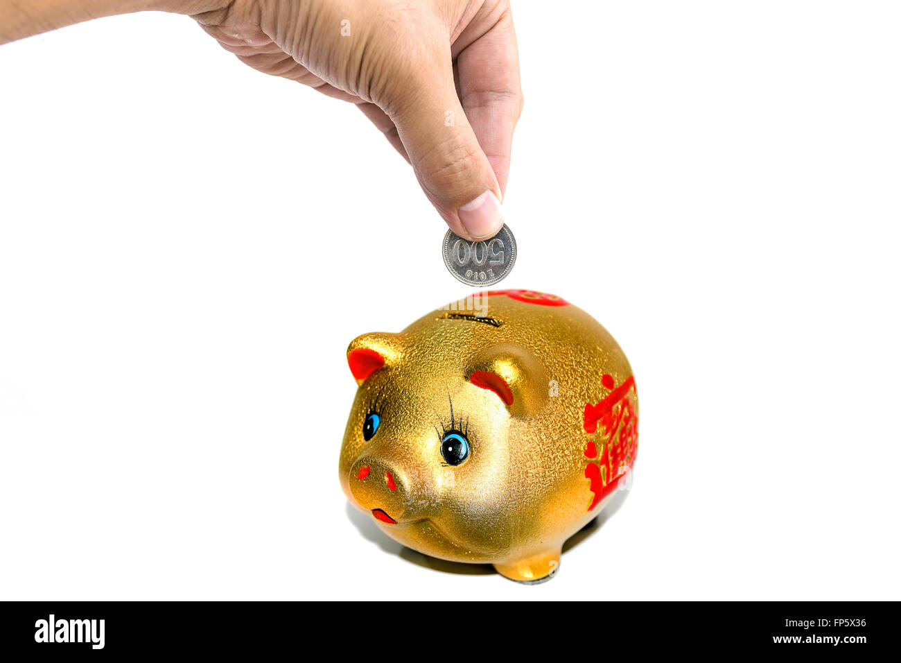 Woman's hand inserting coins into a piggy bank,concept for business finance background. Stock Photo