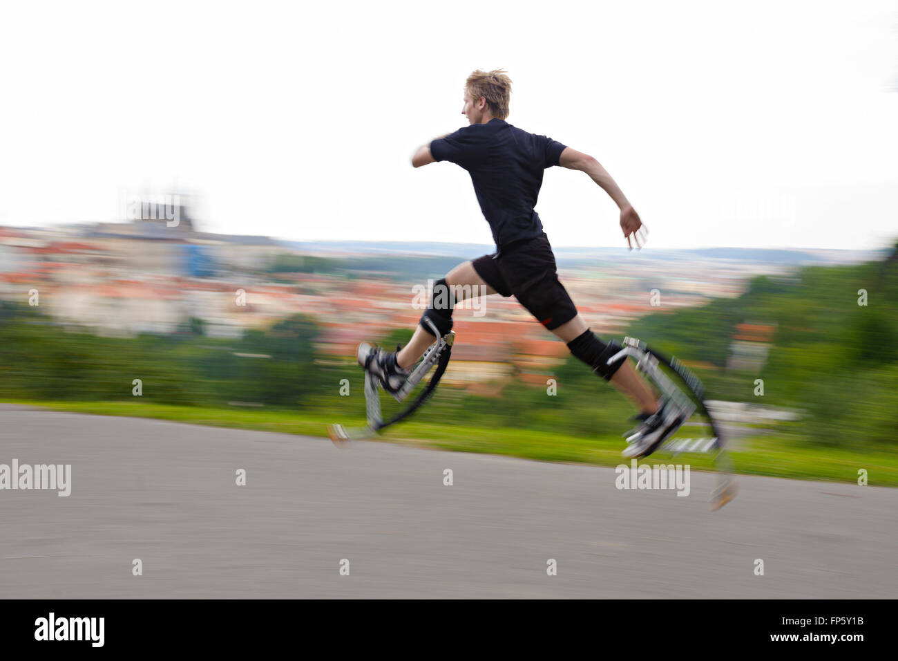 Young man running on a jumping boots Stock Photo - Alamy