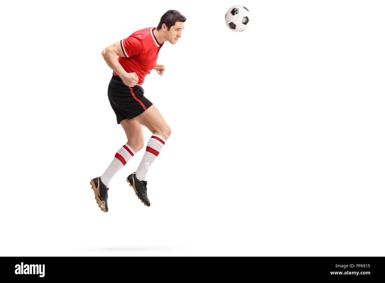 Full length profile shot of a male football player heading a ball shot in mid-air isolated on white background Stock Photo