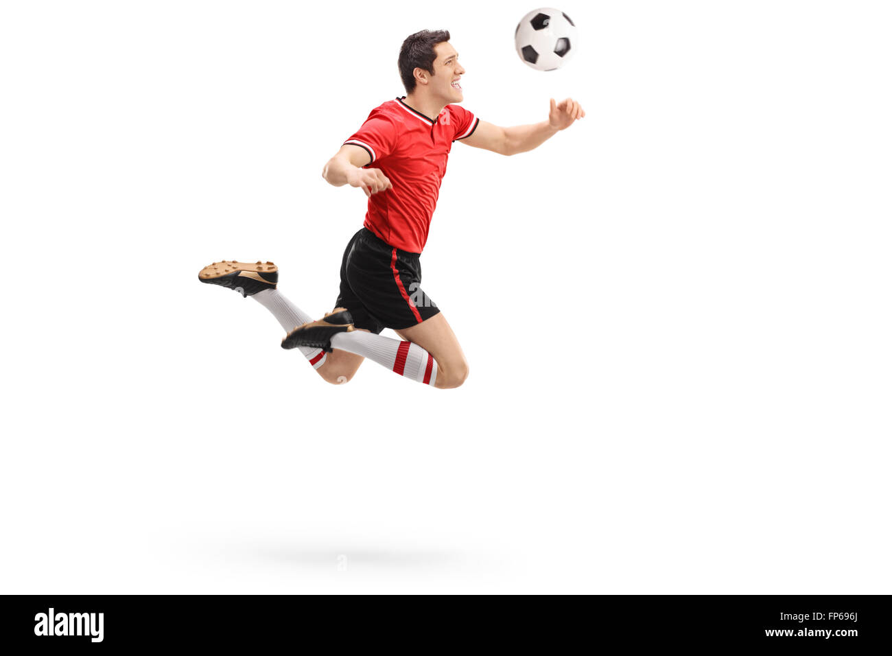 Studio shot of a young football player heading a ball shot in mid-air isolated on white background Stock Photo