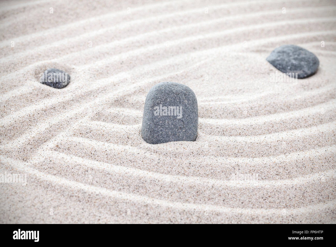 Three stones in sand, zen concept. Stock Photo