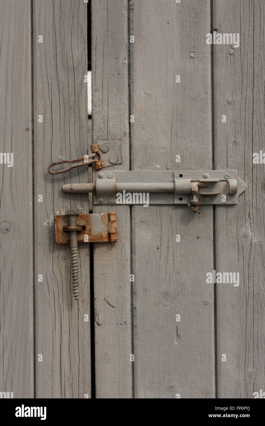 Rusty lock on a grey wooden door Stock Photo - Alamy