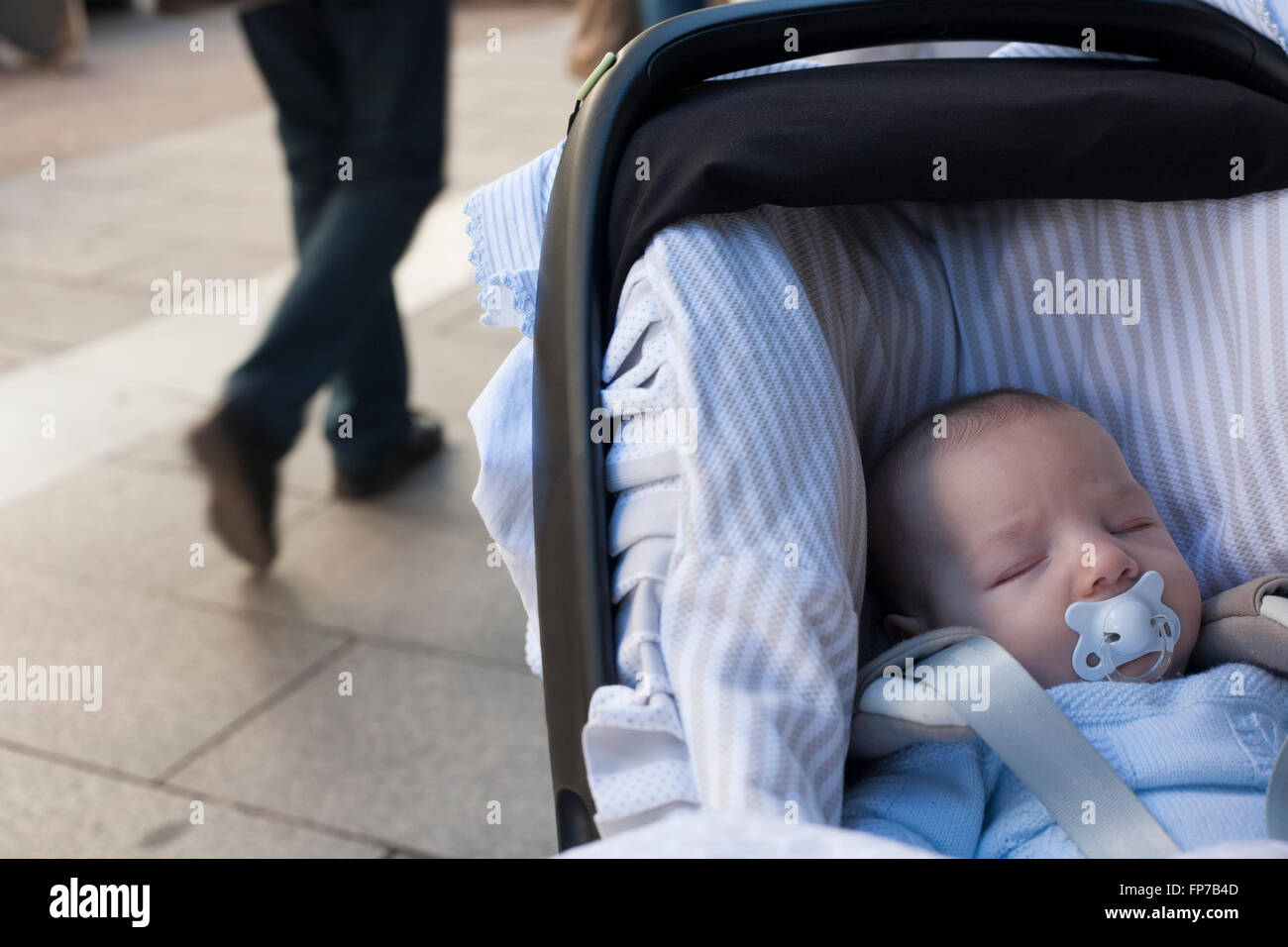 3 months baby boy sleeping in his stroller a sunny day Stock Photo