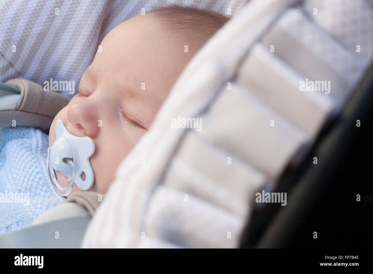 3 months baby boy  sleeping in his stroller a sunny day Stock Photo