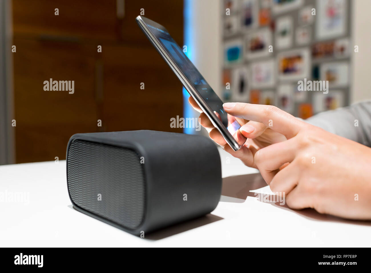 Woman connect their smart-phone to speakers. Nfc, bluetooth, contactless Stock Photo