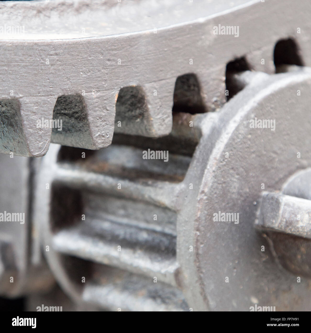 Extreme close up on cast iron gear teeth painted silver for industrial concepts or backgrounds Stock Photo
