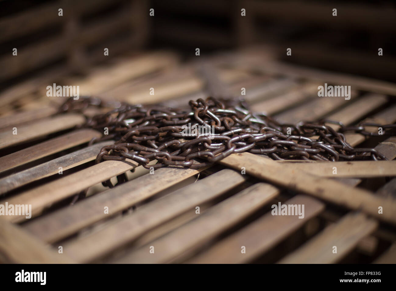 Close-Up Of Rusty Chain On Wooden Box Stock Photo