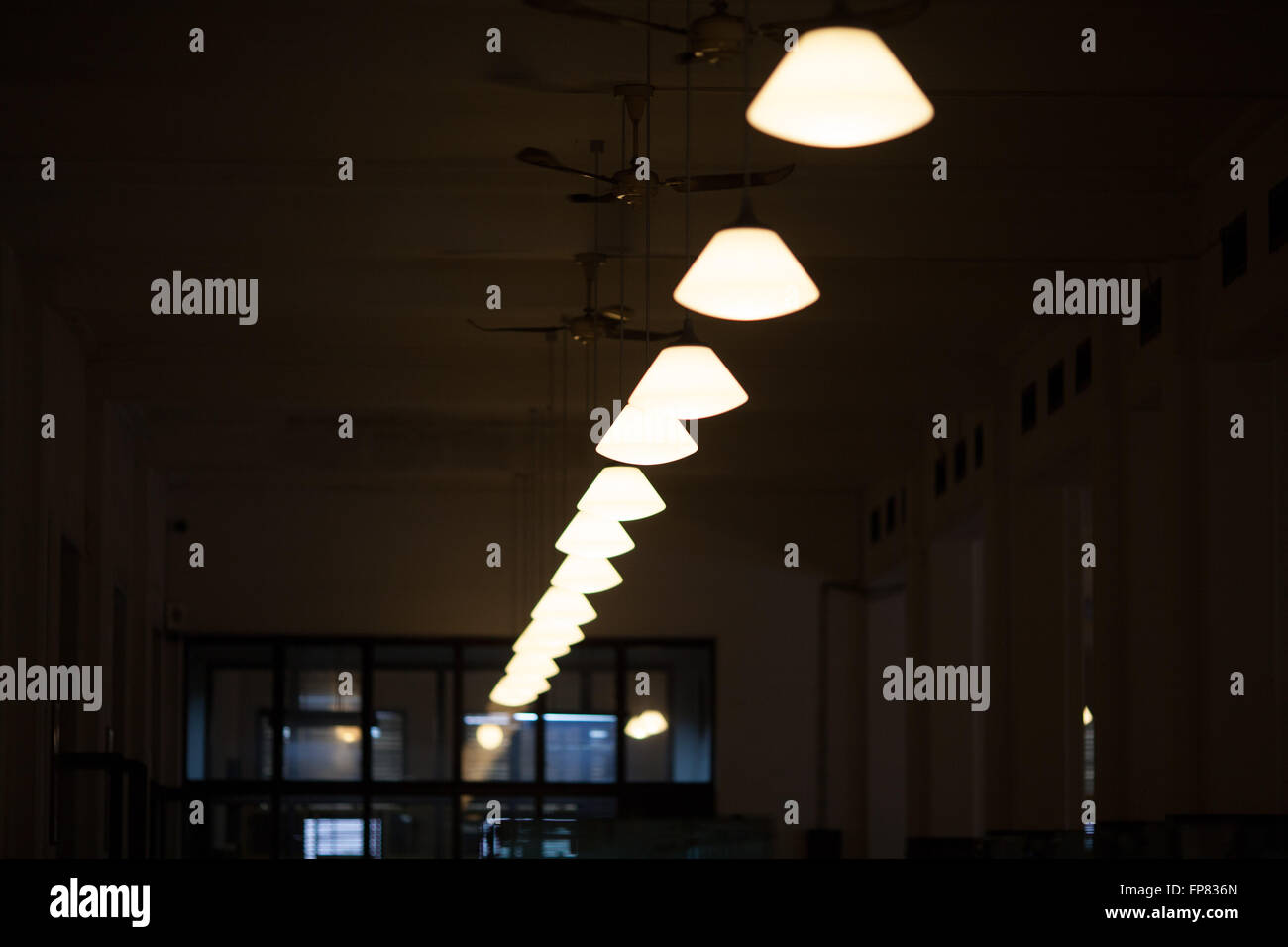 Low Angle View Of Illuminated Pendant Lights Hanging In Darkroom Stock Photo