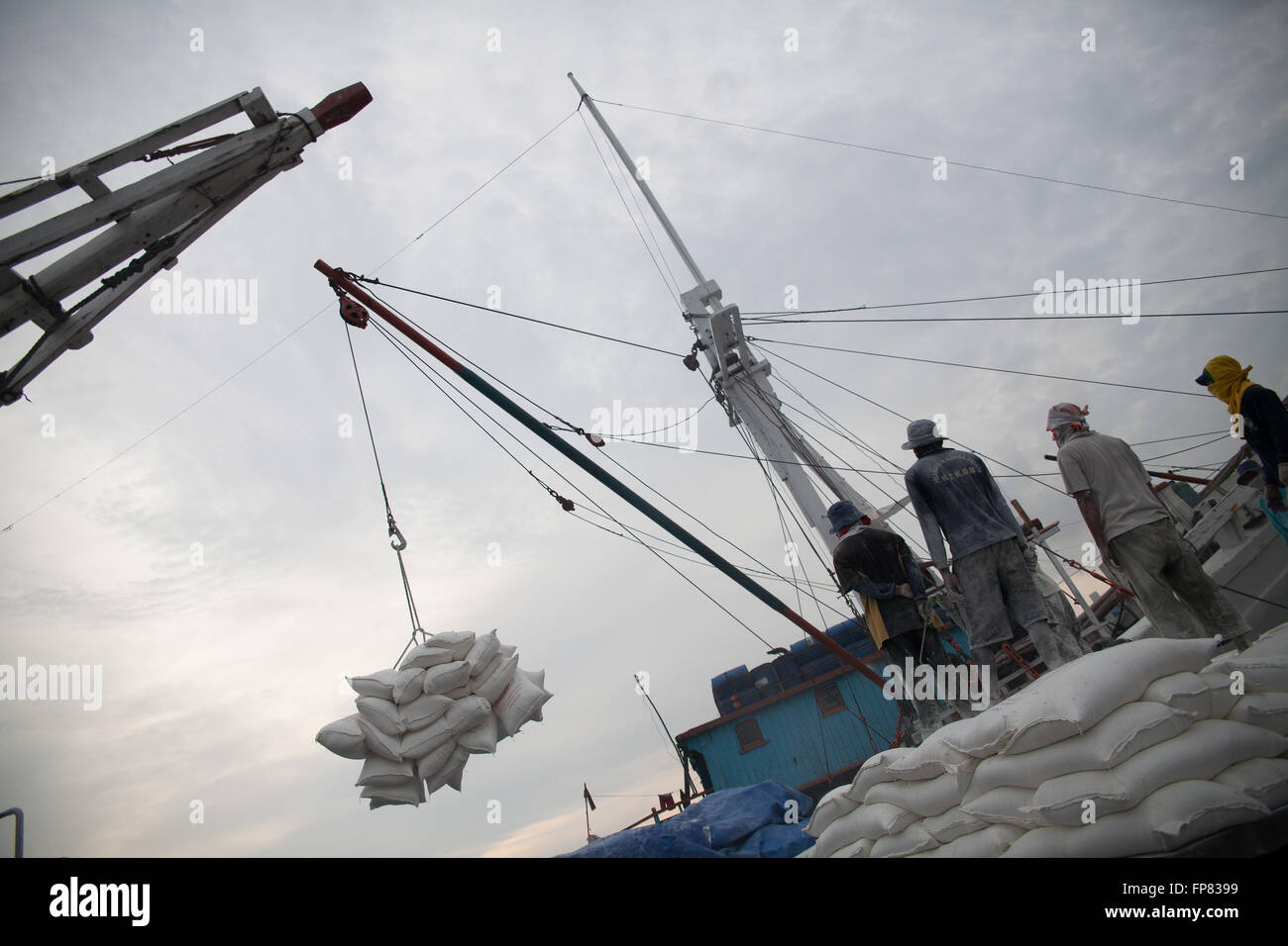 Low Angle View Of Crane Lifting Goods Against Sky Stock Photo