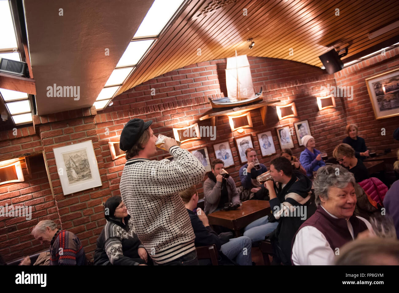 A storyteller entertains customers with old whaling tales in Mack's Beer Hall. Tromso. Norway Stock Photo
