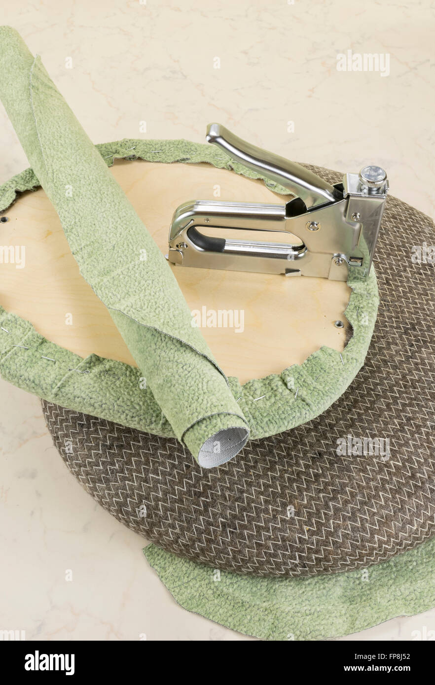 upholstering a part of chair by staple gun Stock Photo