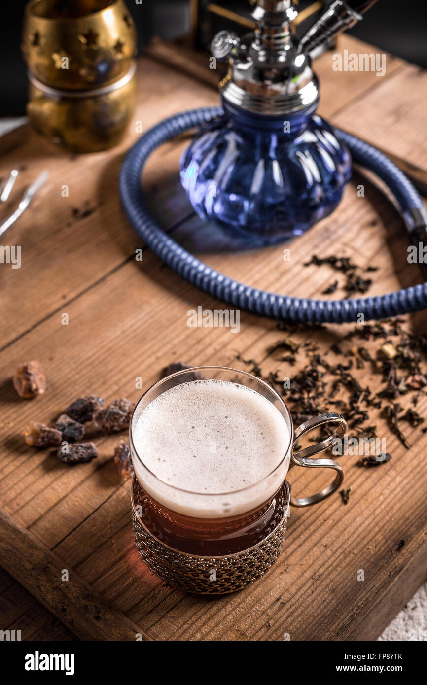 Cup of tea and hookah on old wooden table Stock Photo