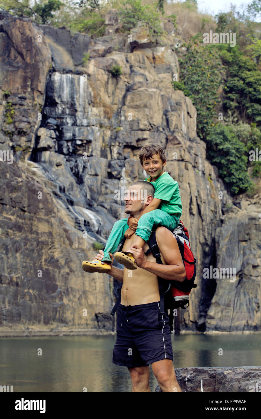 father and son making a trip to waterfall together, happy family on ...