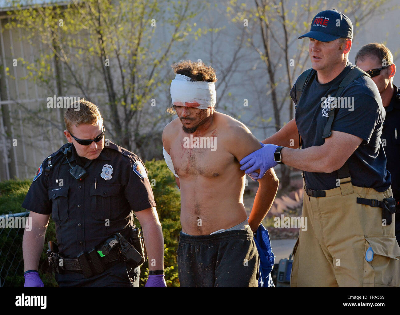 Albuquerque, NM, USA. 17th Mar, 2016. APD officer D. Kisser and AFD firefighter David Auge from station 9 escort Joseph Terrell to the squad car to be transported to the hospital for his wounds he received from a police dog after he refused to come out from hiding. Saturday, Mar. 12, 2016. © Jim Thompson/Albuquerque Journal/ZUMA Wire/Alamy Live News Stock Photo